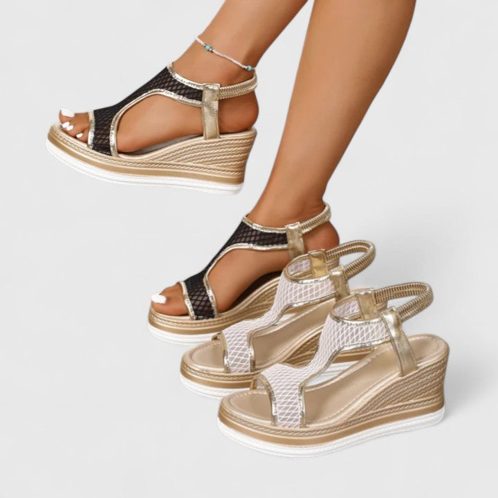 A woman wearing beige chic sandals with a cushioned sole and adjustable strap.