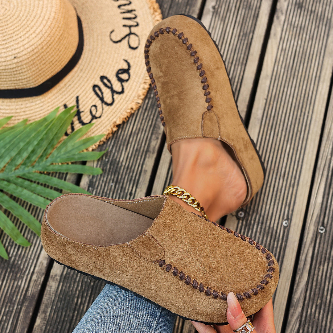 A pair of minimal slip-on loafers in warm brown with a soft footbed and open back