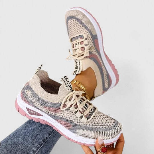 A woman lacing up light, breathable orthopaedic trainers before a walk.
