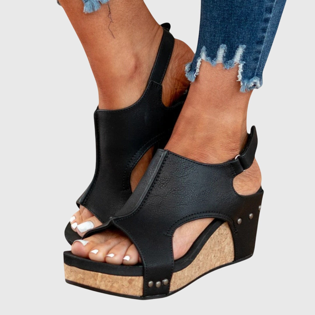 A woman in taupe wedge sandals with an open front, out shopping on a warm day.