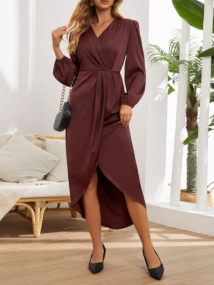 Woman in the Naomi draped evening dress with long sleeves and a softly gleaming finish, ready for an elegant night out.