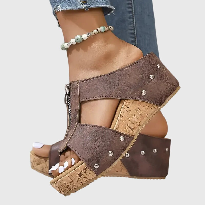 A woman standing comfortably in brown supportive sandals with an adjustable strap and cushioned sole.