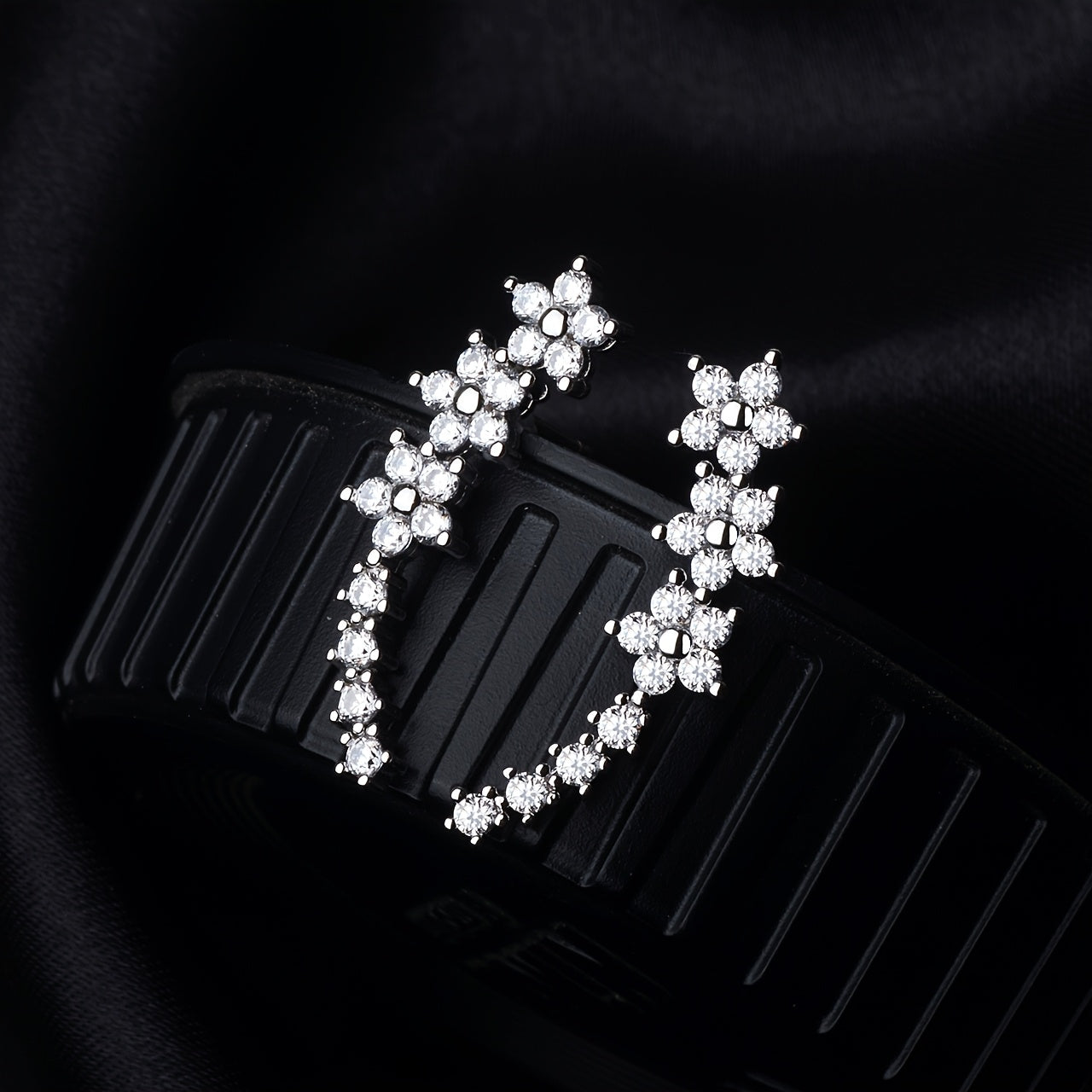 Rose gold floral crawler earrings with delicate sparkling floral motif following the curve of the ear