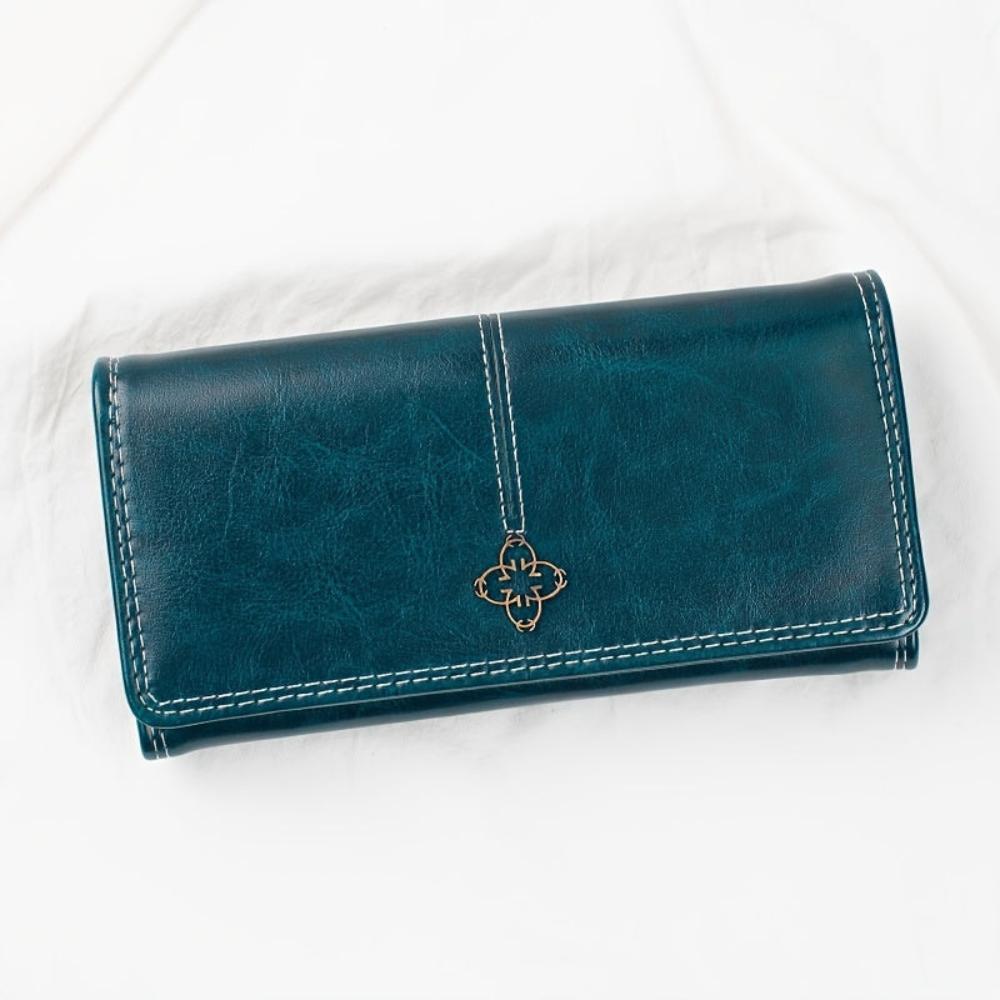 A woman holding an open bifold wallet, tucking a card into its slot.