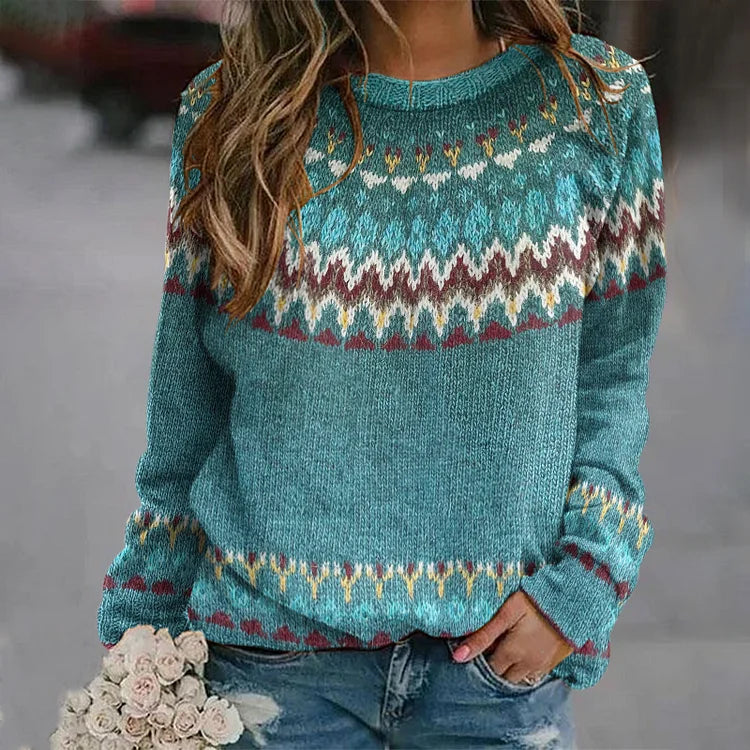 A woman wearing a teal jumper with a colourful retro zigzag pattern and a round neck, relaxed and cosy for autumn.