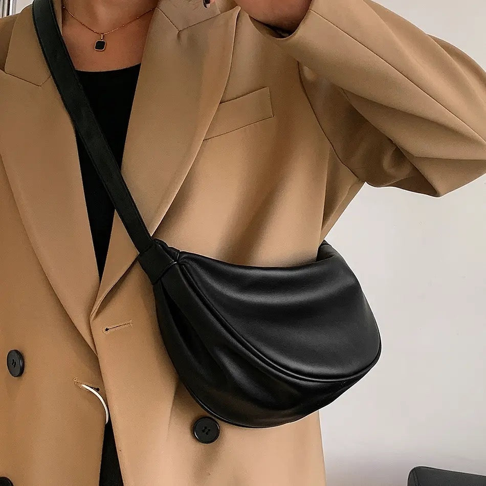 A woman carrying a soft pastel-toned bag with a rich finish on a spring day
