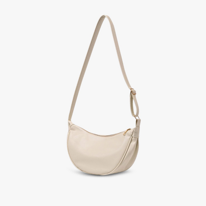 A woman carrying a soft pastel-toned bag with a rich finish on a spring day
