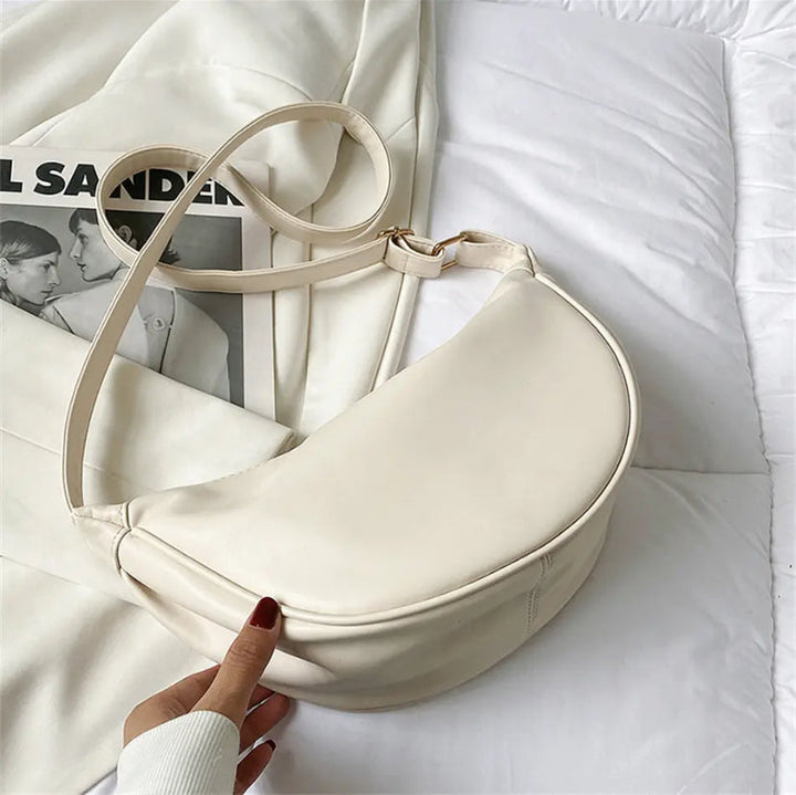 A woman carrying a soft pastel-toned bag with a rich finish on a spring day