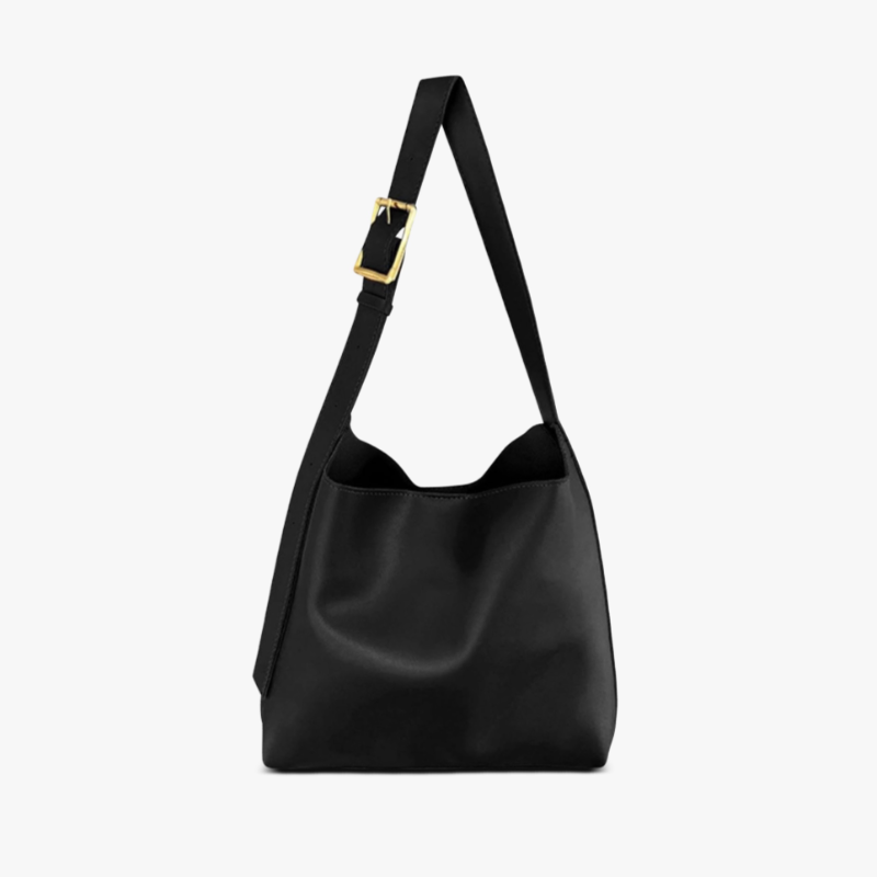 A woman carrying a classic structured handbag over her shoulder