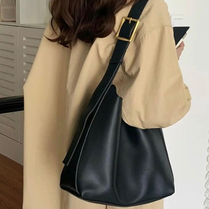 A woman carrying a classic structured handbag over her shoulder