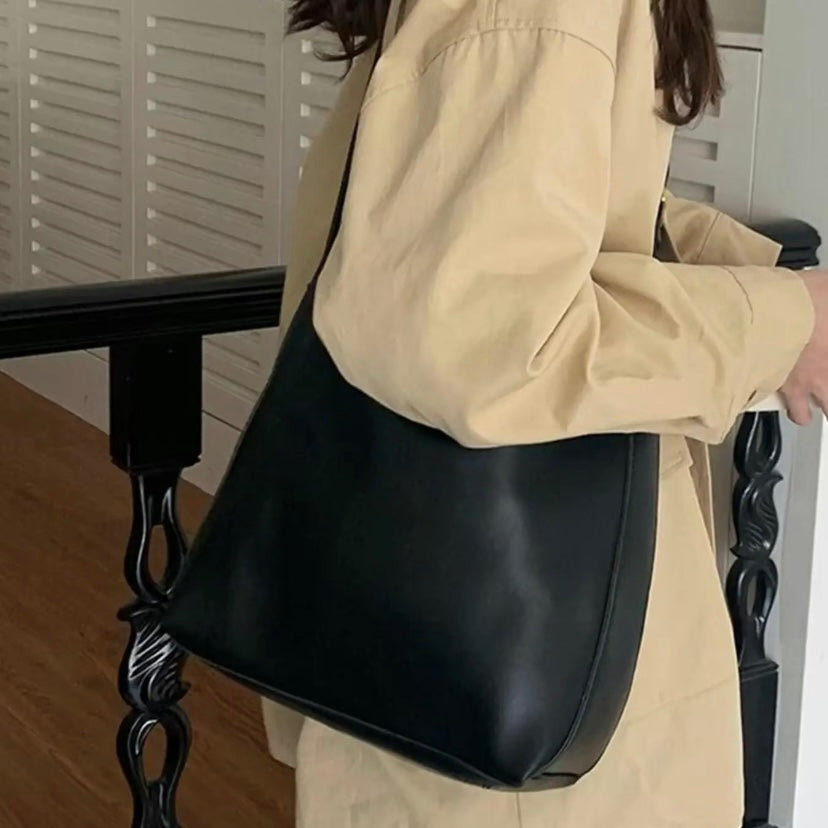 A woman carrying a classic structured handbag over her shoulder