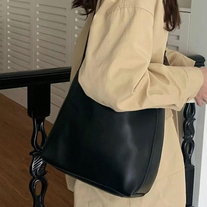 A woman carrying a classic structured handbag over her shoulder