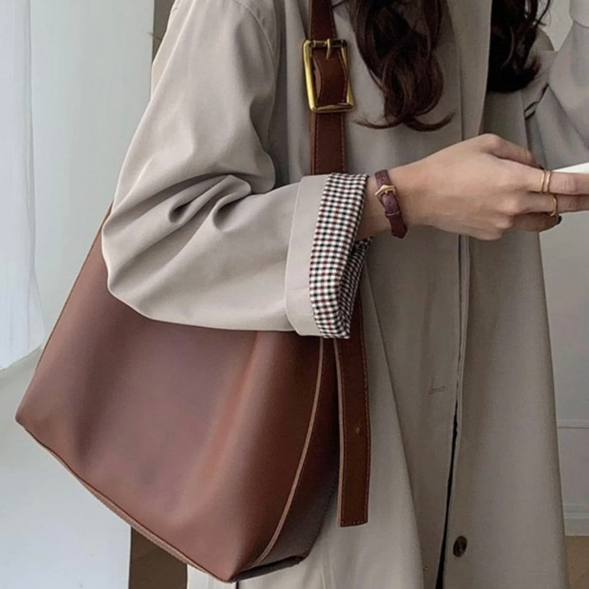 A woman carrying a classic structured handbag over her shoulder