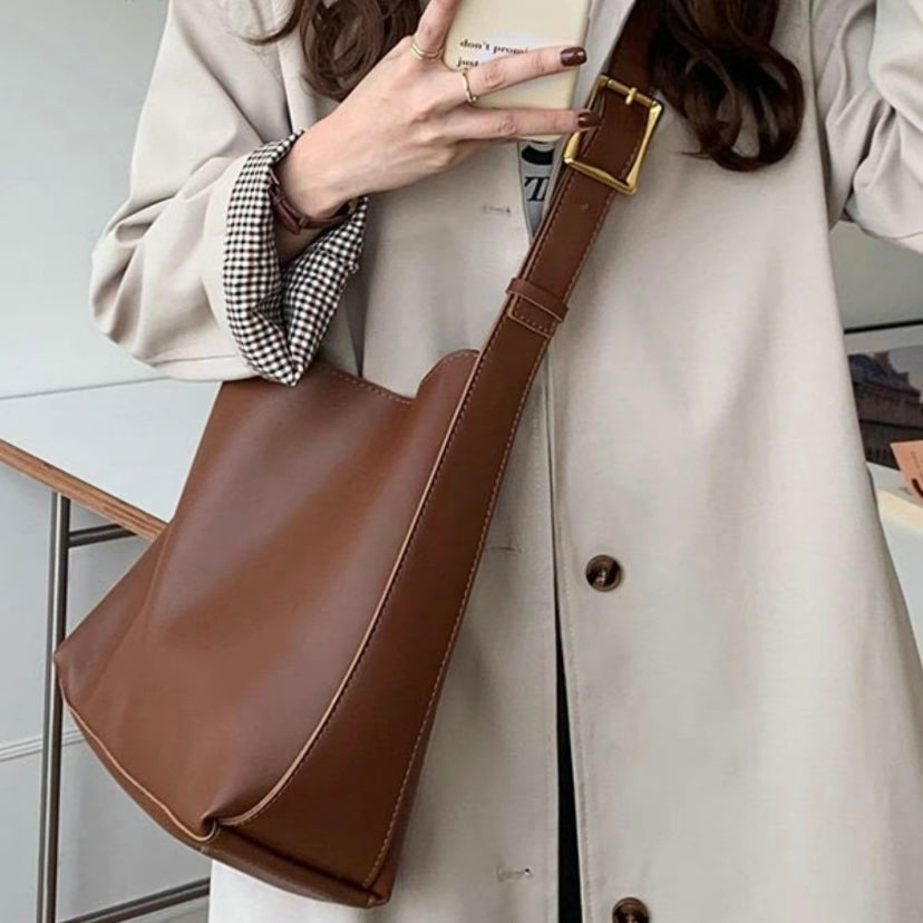 A woman carrying a classic structured handbag over her shoulder