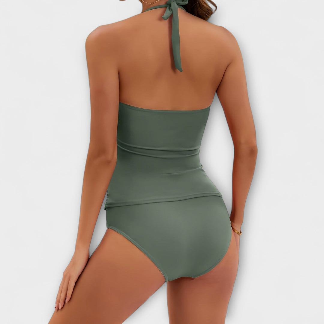 A woman by the water in a lively printed two-piece swimsuit, relaxed and confident in the sun.