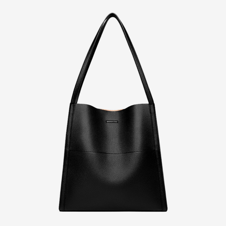 A woman carrying an elegant shoulder bag with clean lines over one shoulder in town