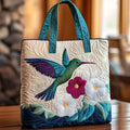 Quilted tote bag with a hummingbird hovering beside a white flower in bloom