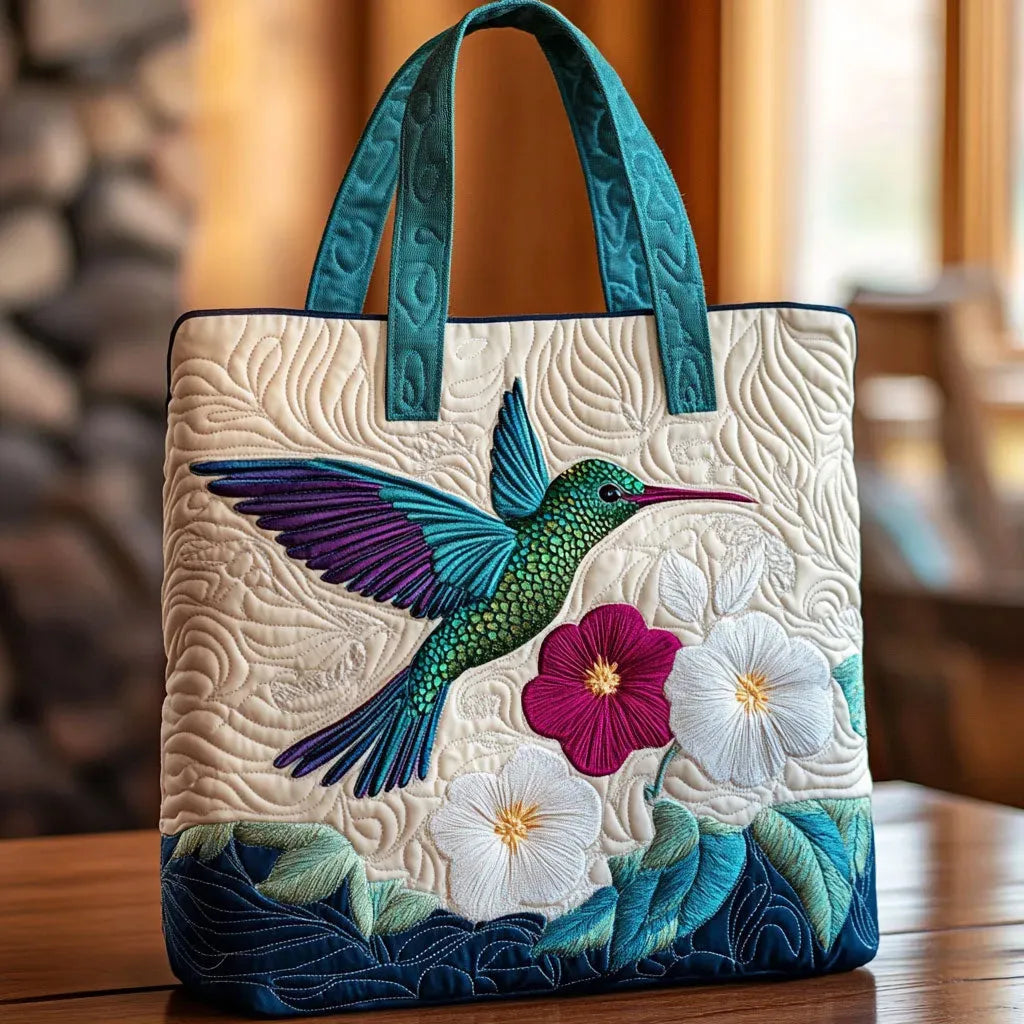 Quilted tote bag with a hummingbird hovering beside a white flower in bloom