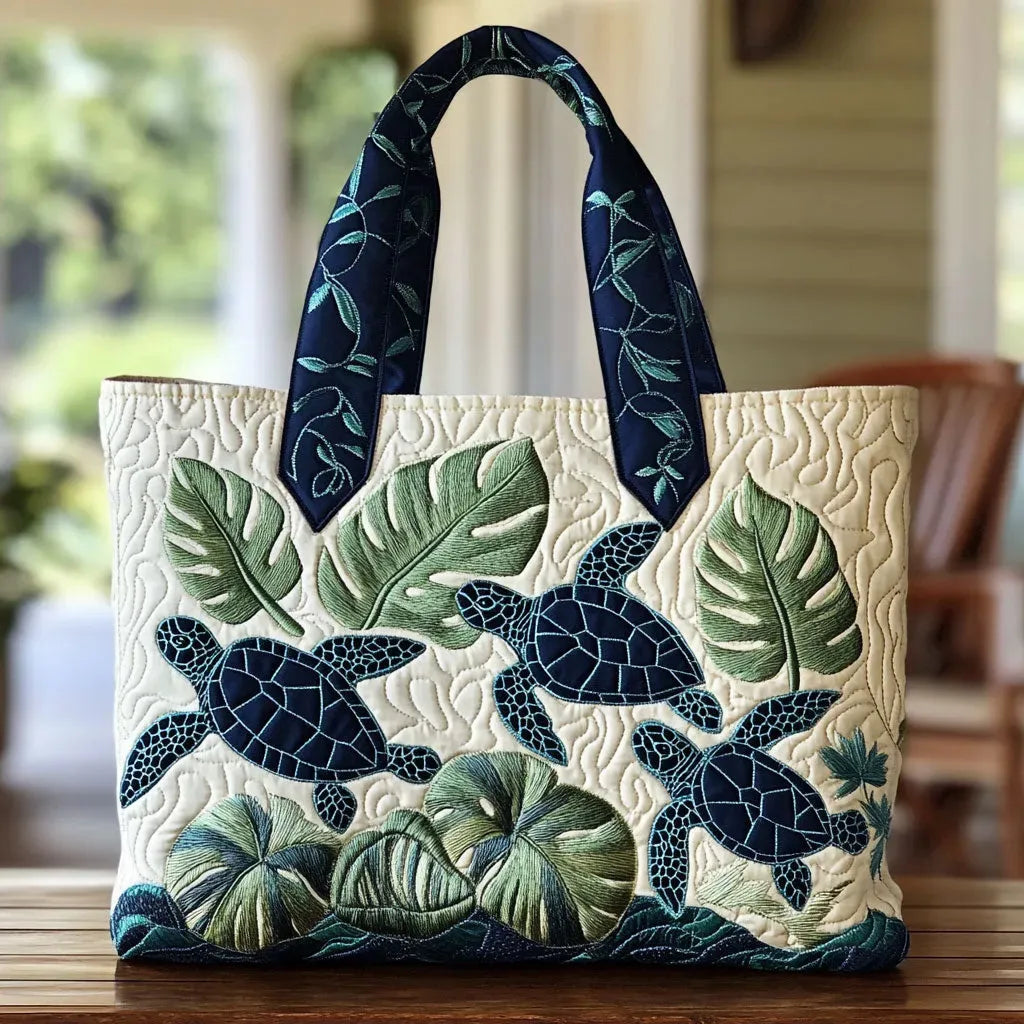 Quilted tote bag with a graceful sea turtle gliding through deep ocean blue on a structured padded body
