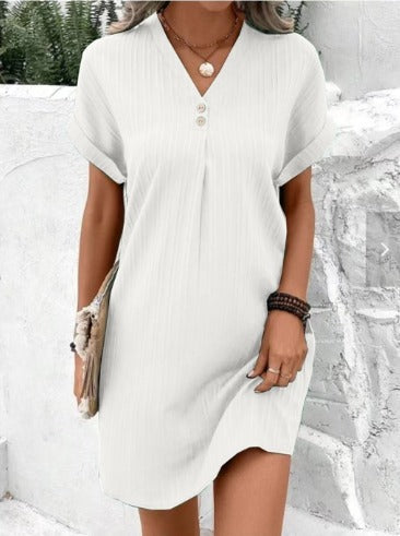Woman wearing the Martha layered V-neck dress, relaxed and smiling at a spring lunch with friends.