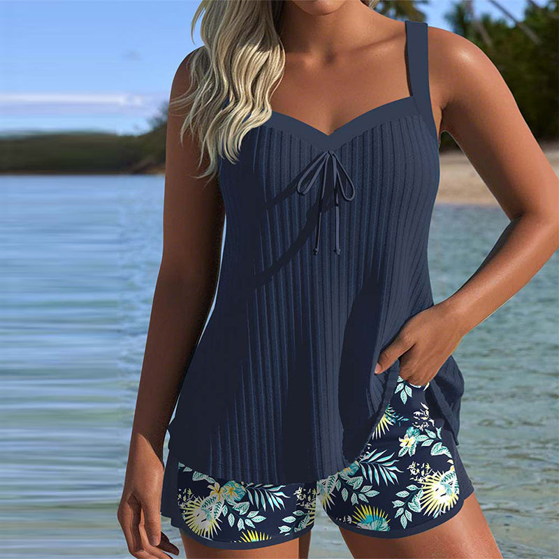 Navy and white striped tankini with matching shorts bottom, laid flat on a bright background