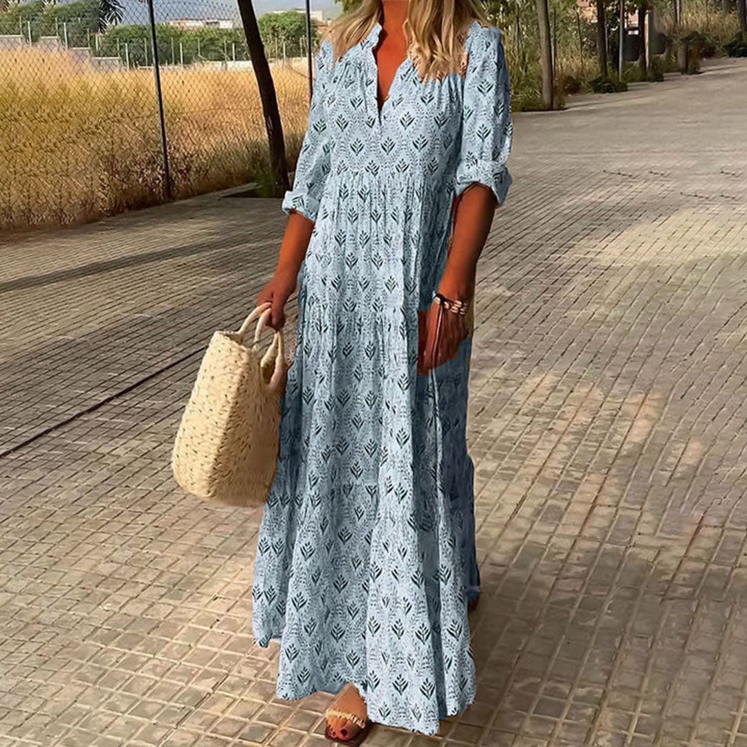 Woman wearing the Imelda™ elegant boho maxi dress with a V-neckline and flowing skirt at a summer occasion.