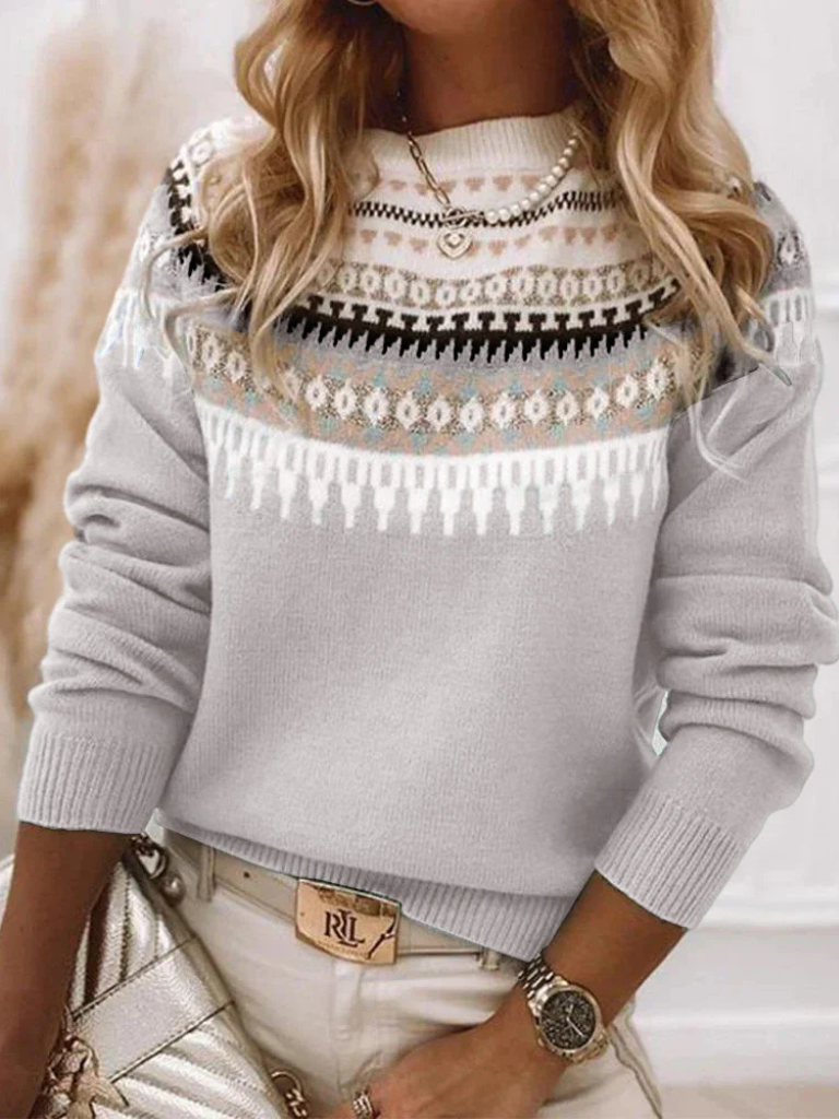 A woman wearing a soft jumper with a cream, black and beige Nordic pattern, warm and elegant.