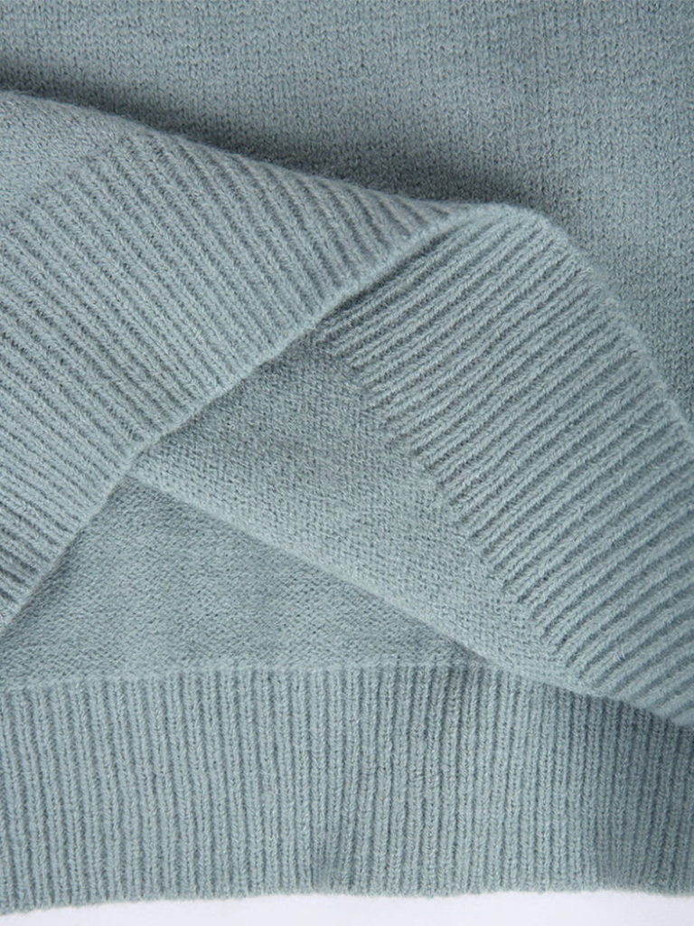 A woman wearing a soft jumper with a cream, black and beige Nordic pattern, warm and elegant.