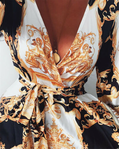 Woman at golden hour wearing the Tessa vintage print maxi dress with a waist belt and long statement sleeves.