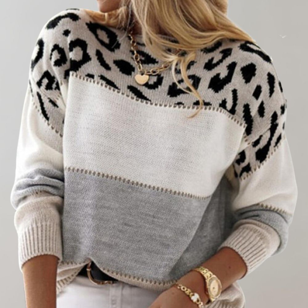 A woman wearing a grey leopard-print jumper, cosy and stylish, paired with jeans.