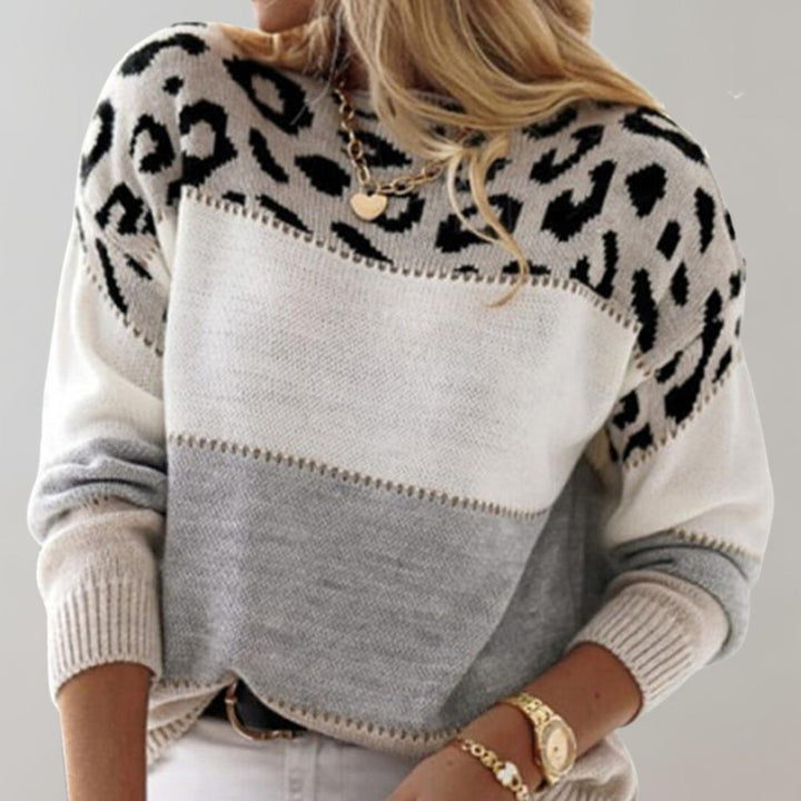 A woman wearing a grey leopard-print jumper, cosy and stylish, paired with jeans.