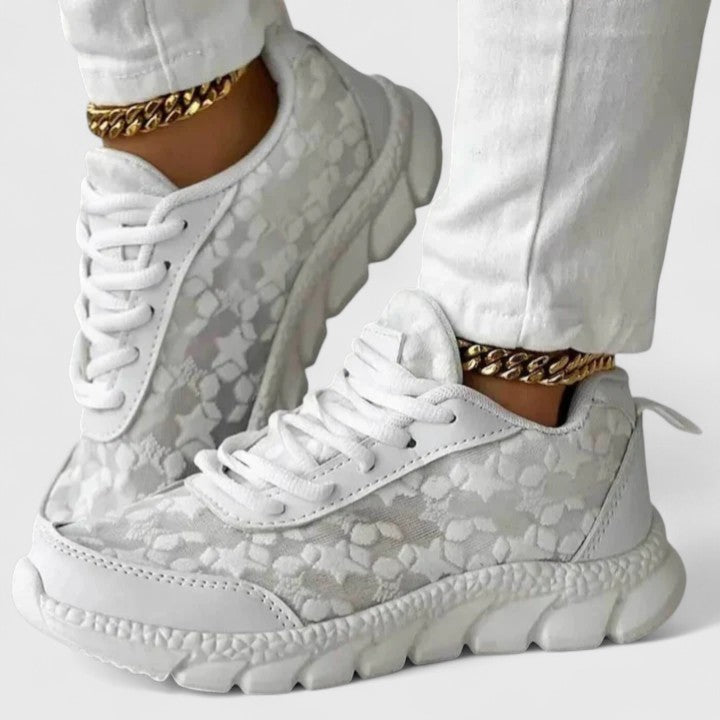 A woman wearing clean white cushioned comfort trainers