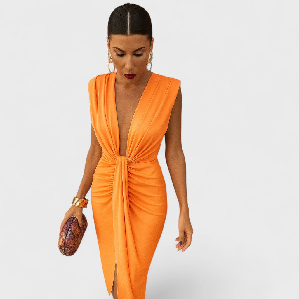 A pleated midi dress with open neckline in soft orange, photographed in natural light