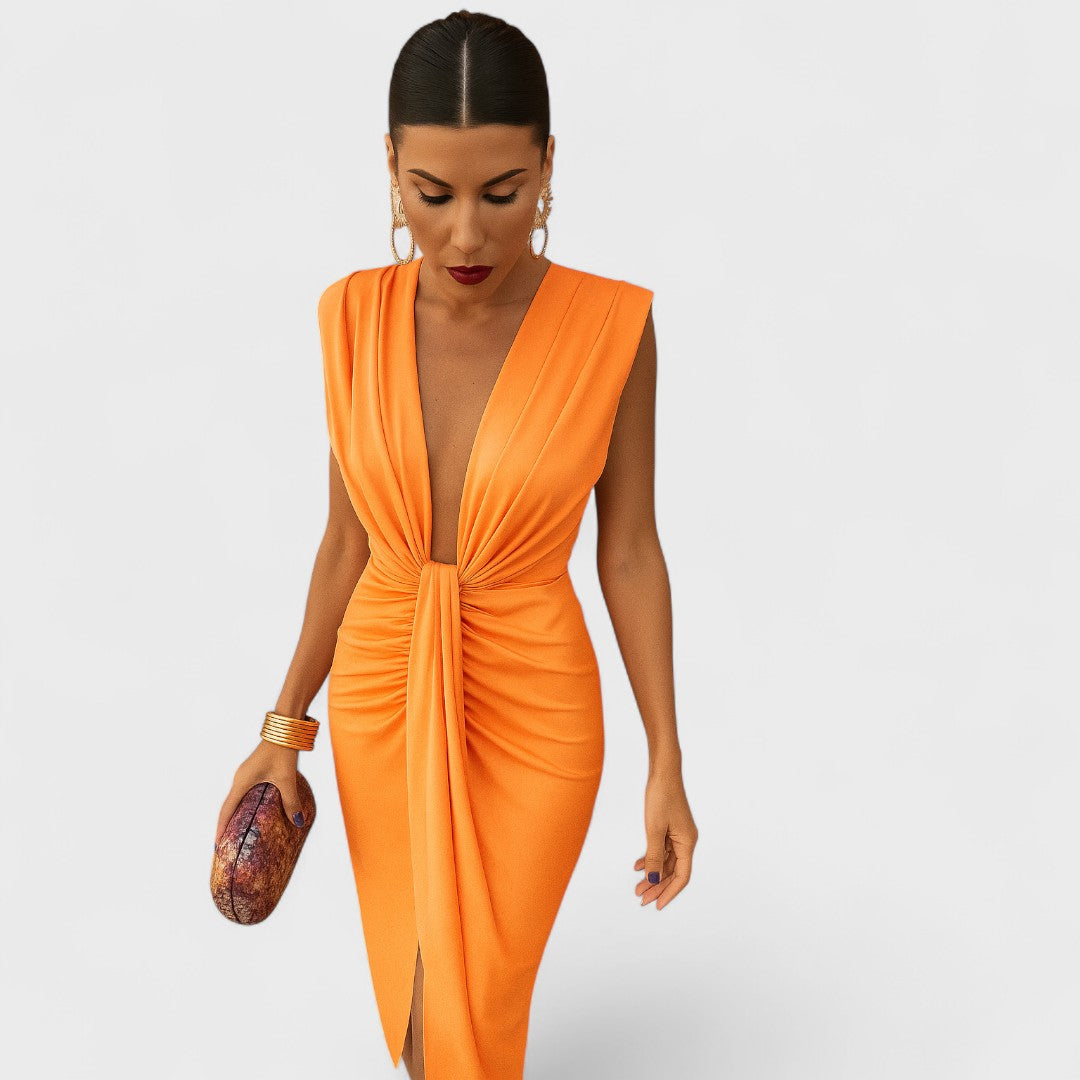 A pleated midi dress with open neckline in soft orange, photographed in natural light