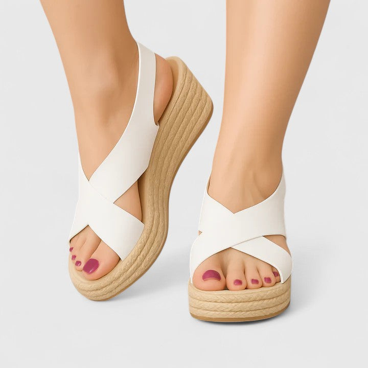A woman in white crossover platform sandals standing comfortably, feet relaxed and supported.