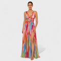 A fluid printed summer dress in a vibrant artistic pattern, styled for an outdoor occasion