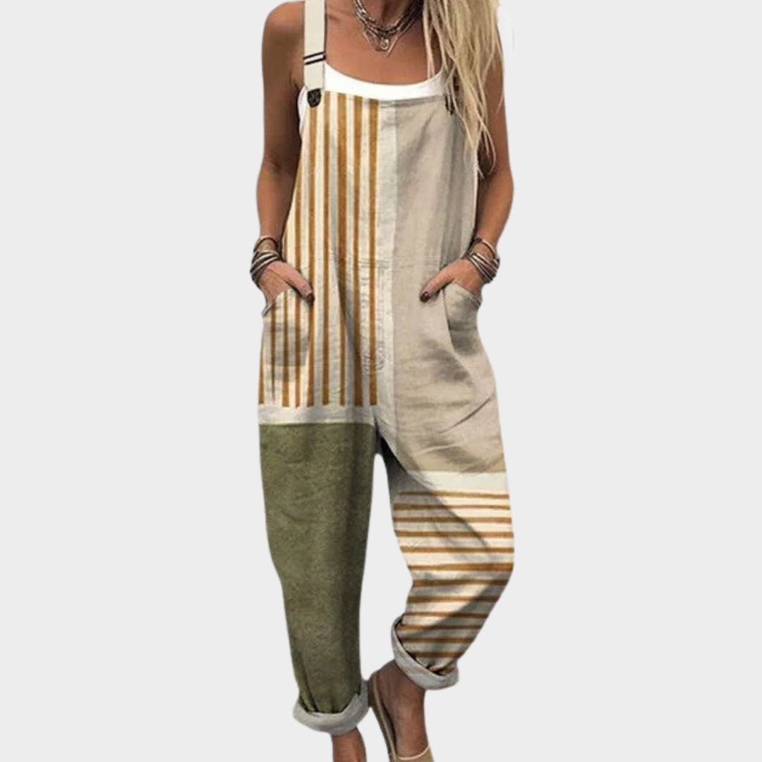 Woman wearing beige and olive vertical-striped dungarees with adjustable straps, relaxed and at ease.