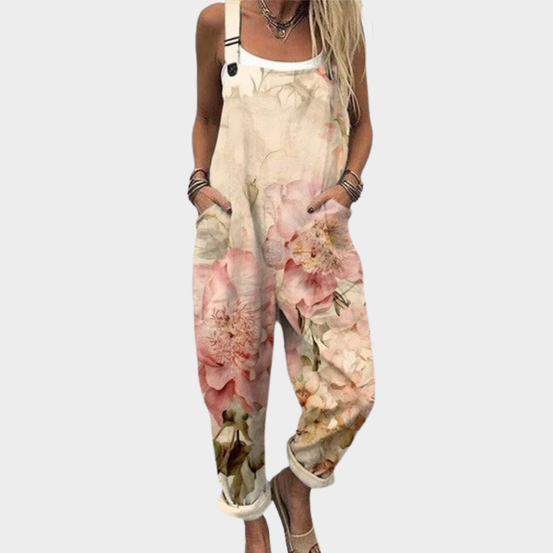 Woman wearing cream dungarees with soft pink watercolour roses, adjustable straps, relaxed and graceful.