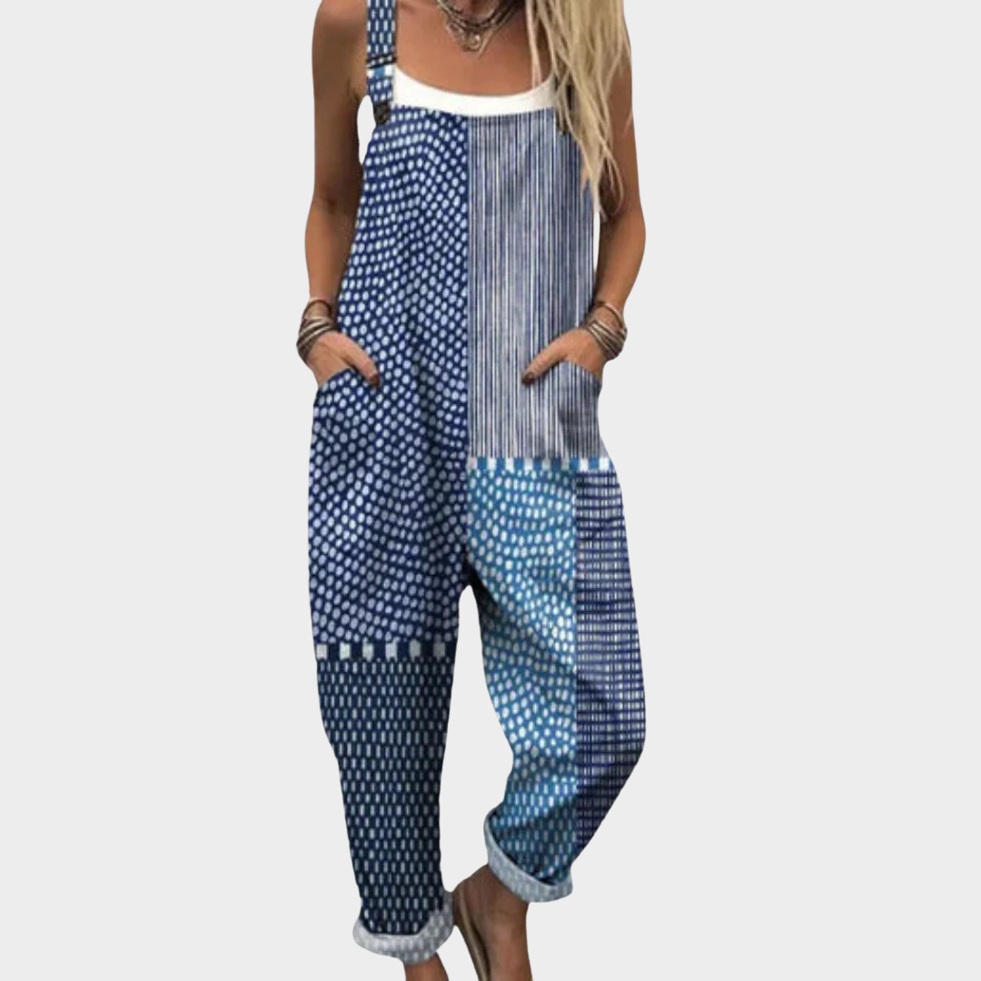Woman wearing blue and white boho patchwork dungarees with dots and stripes, adjustable straps, relaxed and free-spirited.