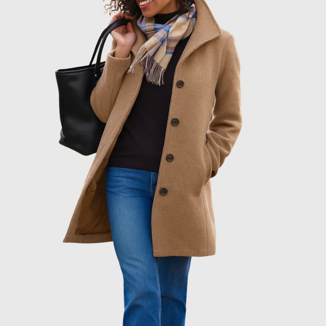 A woman wearing an elegant single-button coat over a jumper on a crisp autumn day.