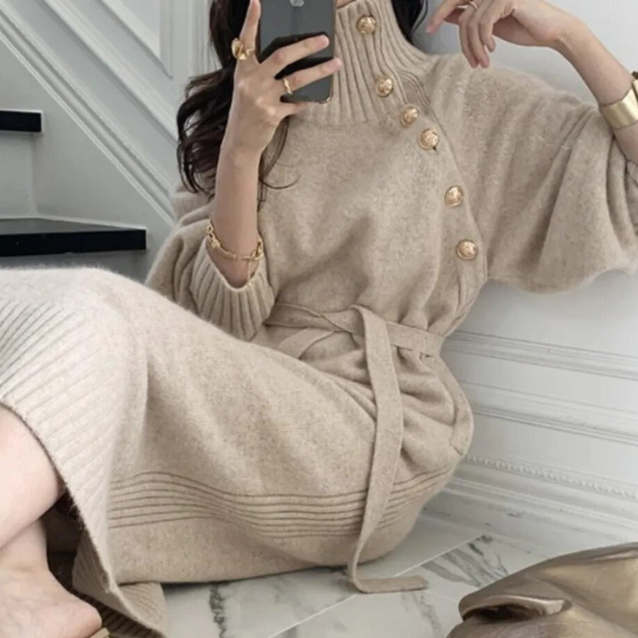 Woman in the Rosa cosy wrap dress with gold-tone buttons and a waist tie, holding a warm drink at home.