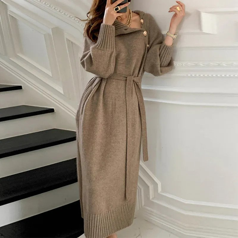 Woman in the Rosa cosy wrap dress with gold-tone buttons and a waist tie, holding a warm drink at home.