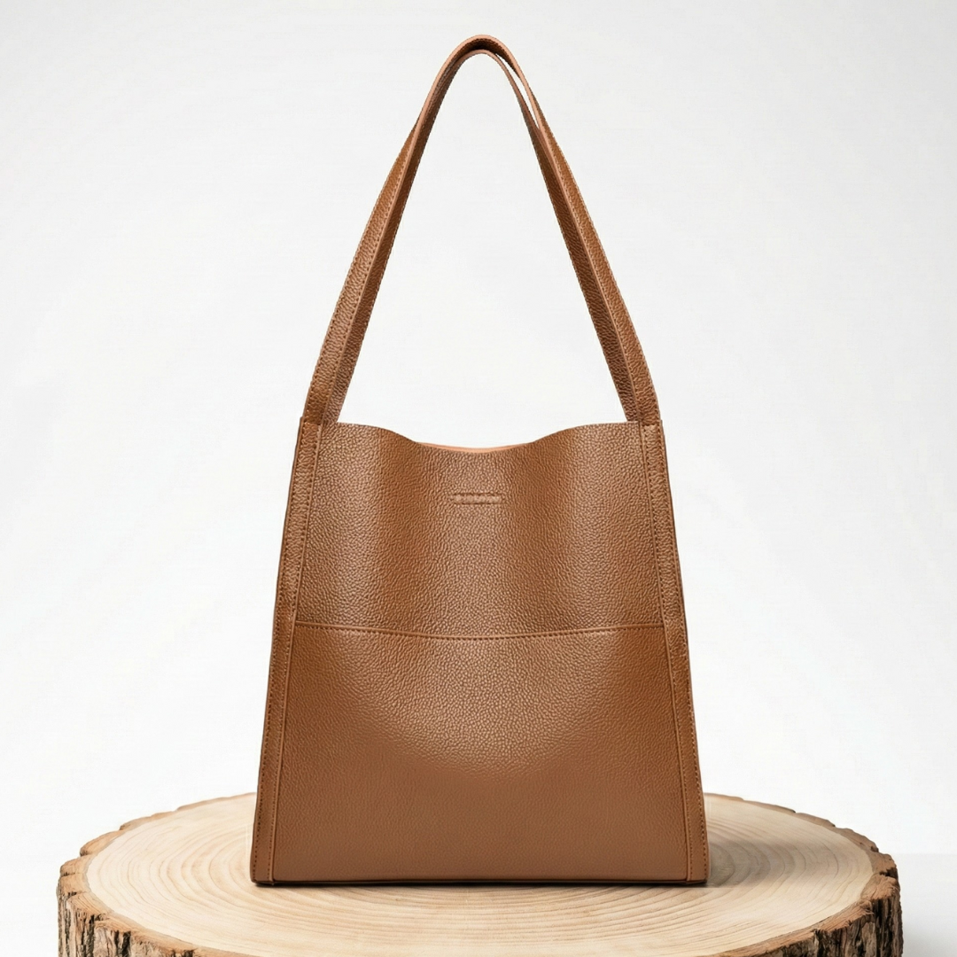 A woman carrying an elegant shoulder bag with clean lines over one shoulder in town