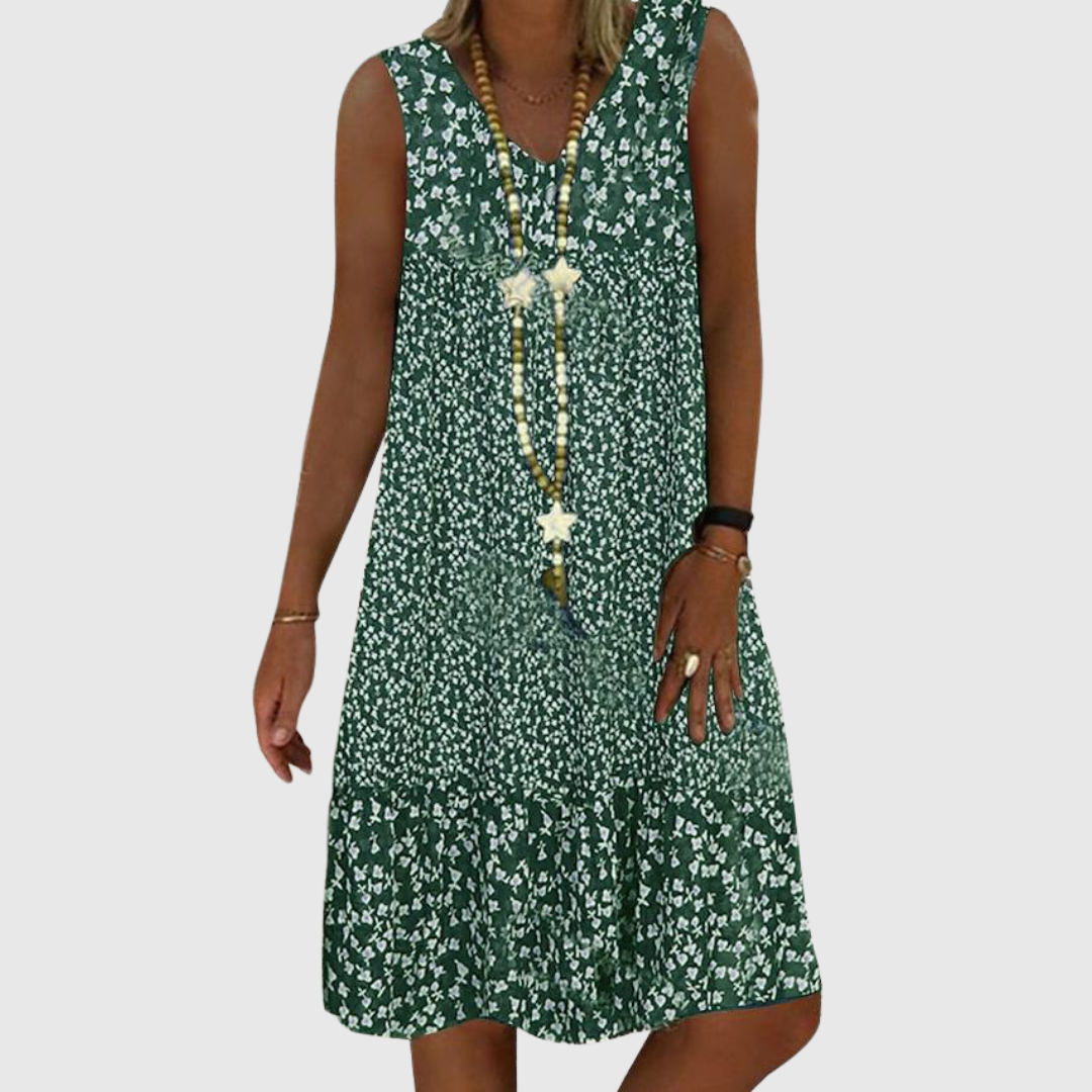 A woman wearing the Geraldine sleeveless V-neck floral dress on a sunny day outdoors.