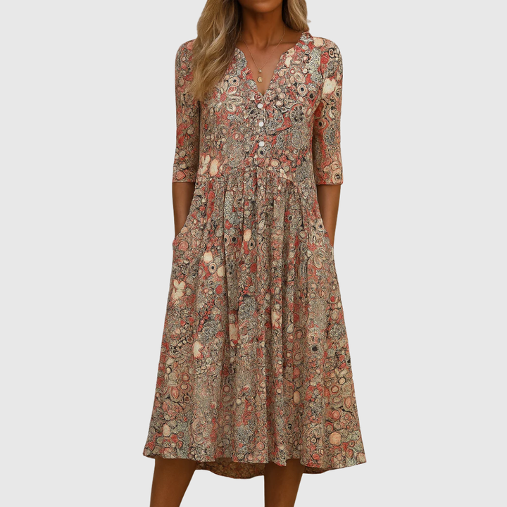 Woman wearing the Laura elegant V-neck dress with three-quarter sleeves, walking through a city street.