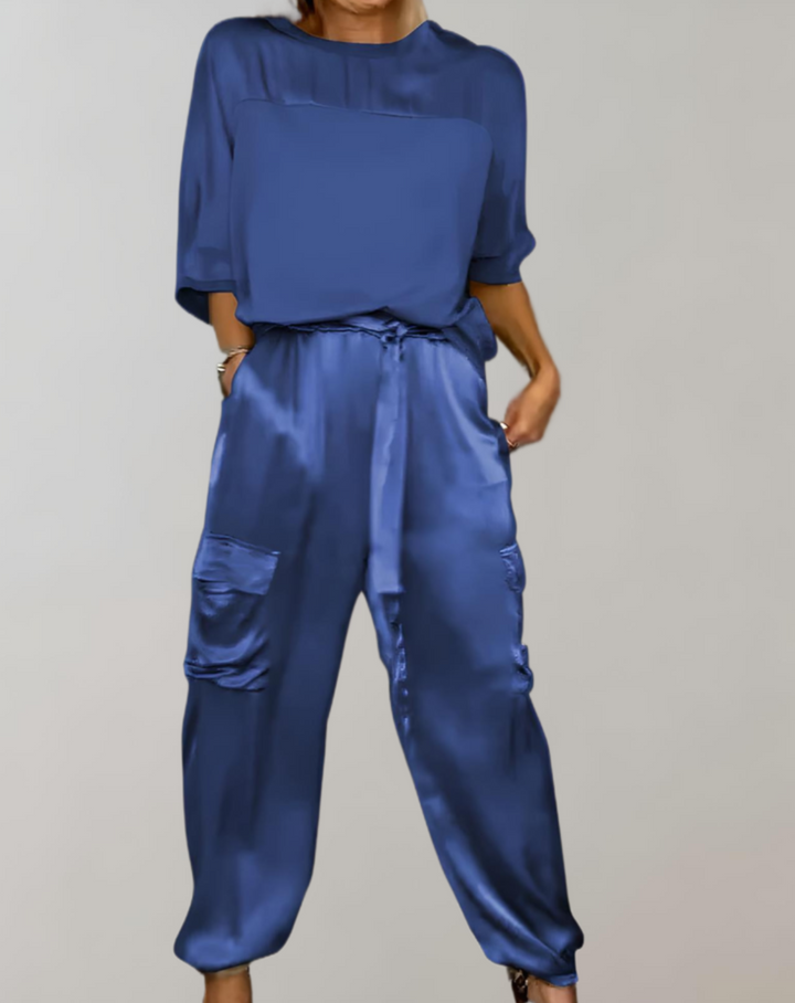 A woman wearing a silky-finish cargo top and trousers lounge set with pockets.