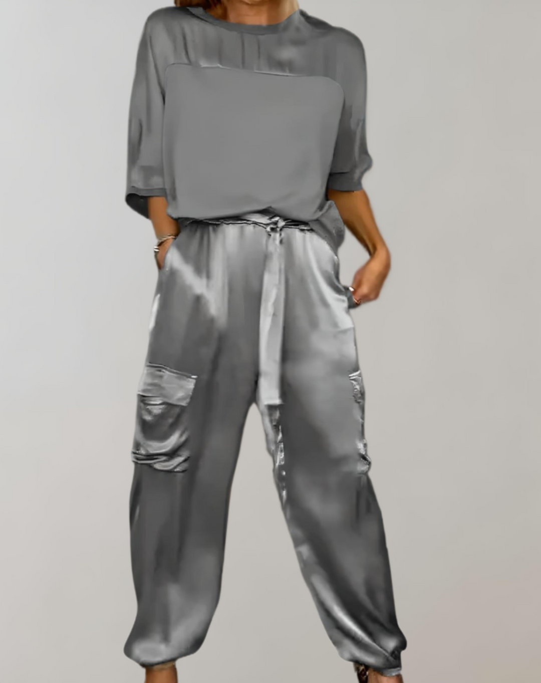 A woman wearing a silky-finish cargo top and trousers lounge set with pockets.