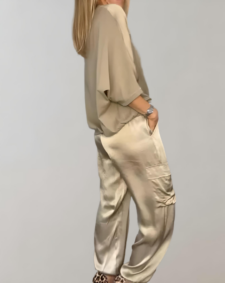 A woman wearing a silky-finish cargo top and trousers lounge set with pockets.