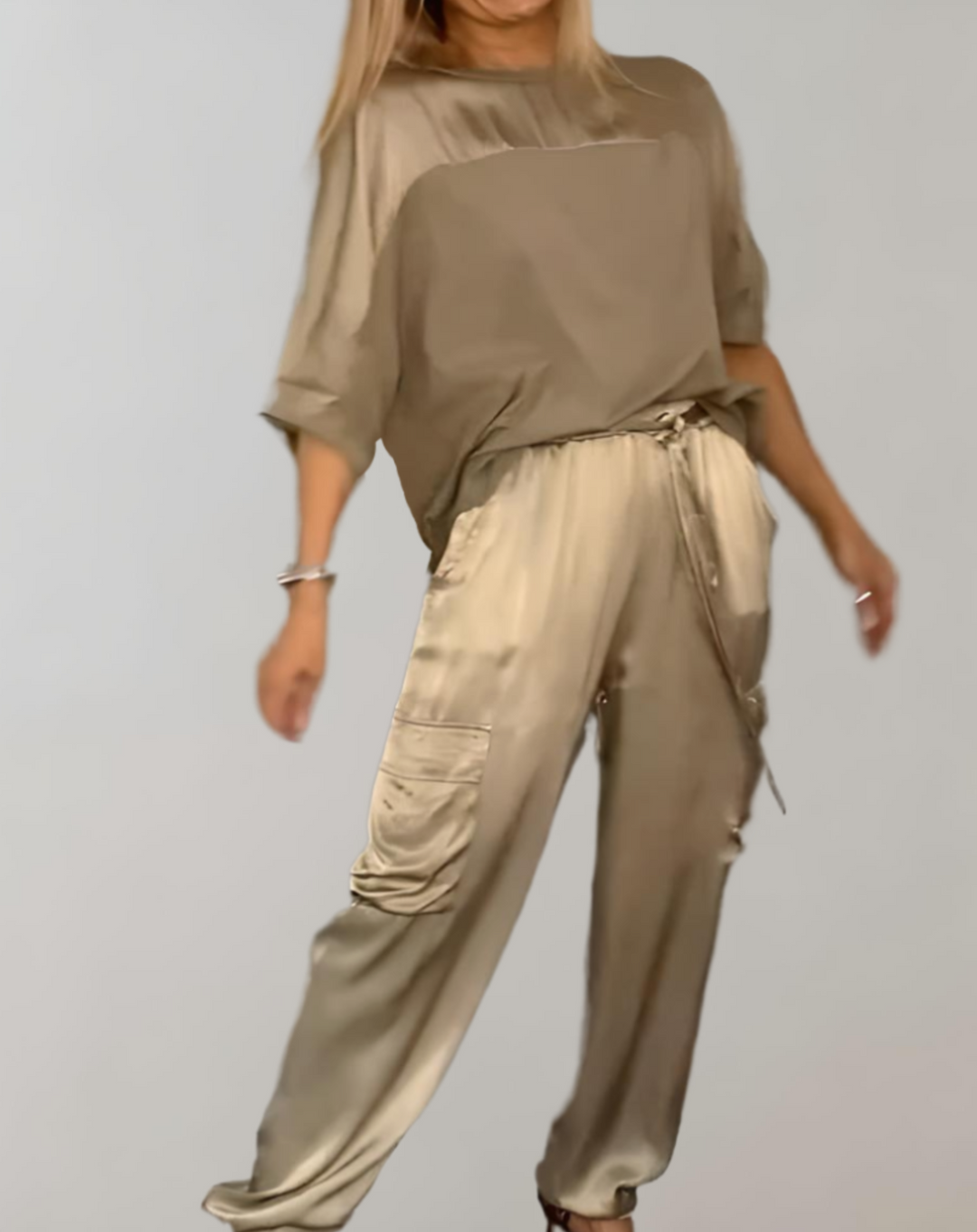 A woman wearing a silky-finish cargo top and trousers lounge set with pockets.