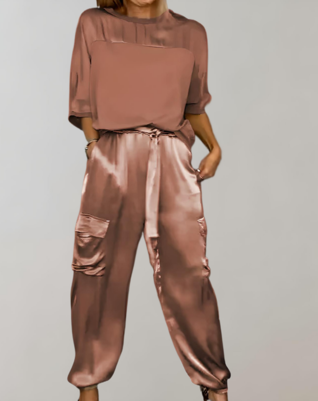 A woman wearing a silky-finish cargo top and trousers lounge set with pockets.